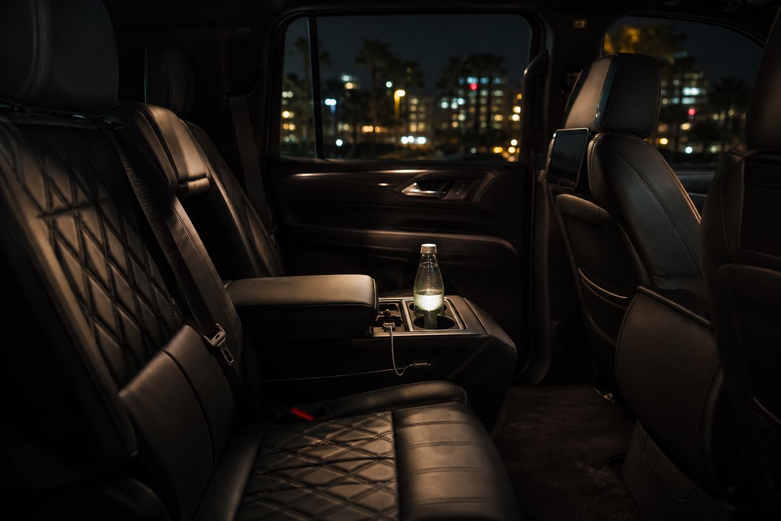 An immaculate luxury SUV cabin prepared with water and phone charging for an hourly charter.